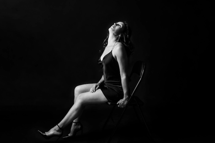 Portrait Signature d’une femme sur fond sombre.