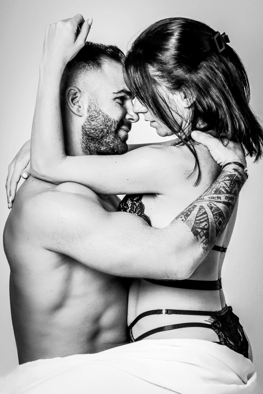 Couple enlacé en noir et blanc pendant une séance au studio.