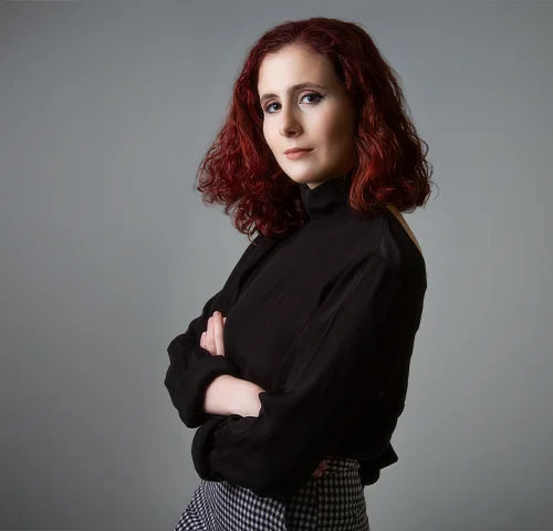 Portrait de femme rousse aux bras croisés, regard affirmé, lors d'une séance Portrait Signature à Lyon