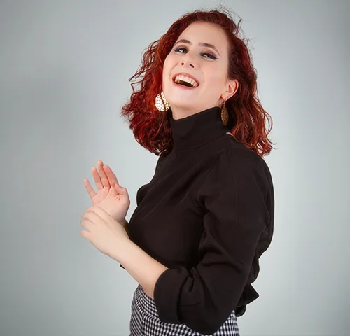 Femme rousse riant devant l'objectif pendant une séance Portrait Signature à Lyon